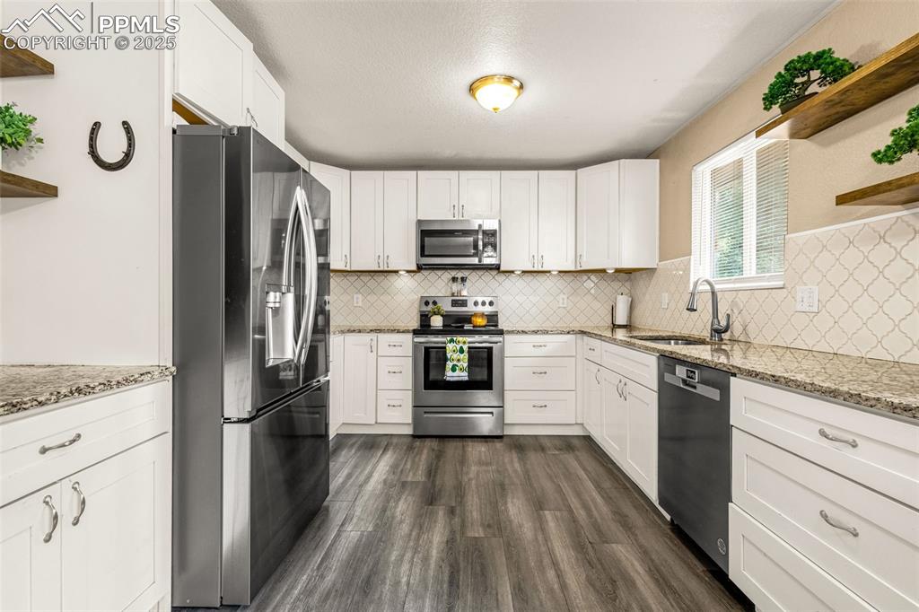 Image 7 of 34: Kitchen featuring open shelves, appliances with stainless steel finishes, d
