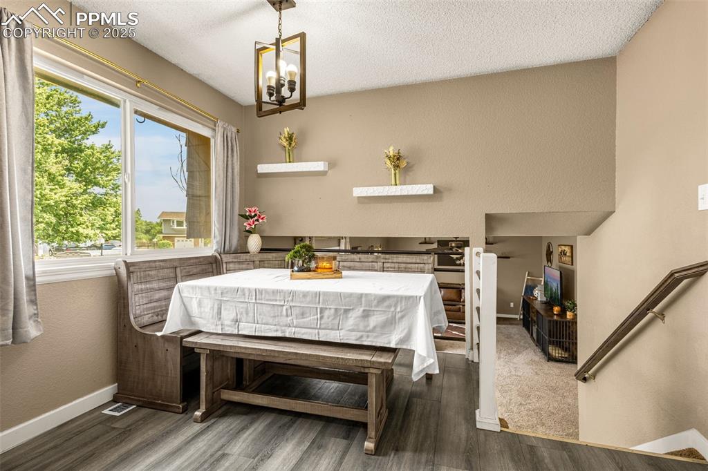 Image 9 of 34: Dining area featuring healthy amount of natural light, dark wood finished f