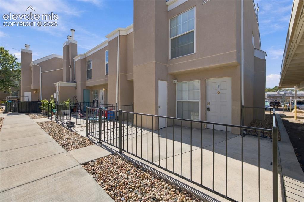 Image 1 of 26: Stucco exterior with multiple windows, individual front entry with a securi