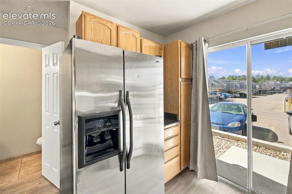Image 10 of 26: Modern kitchen featuring stainless steel side-by-side refrigerator with ice