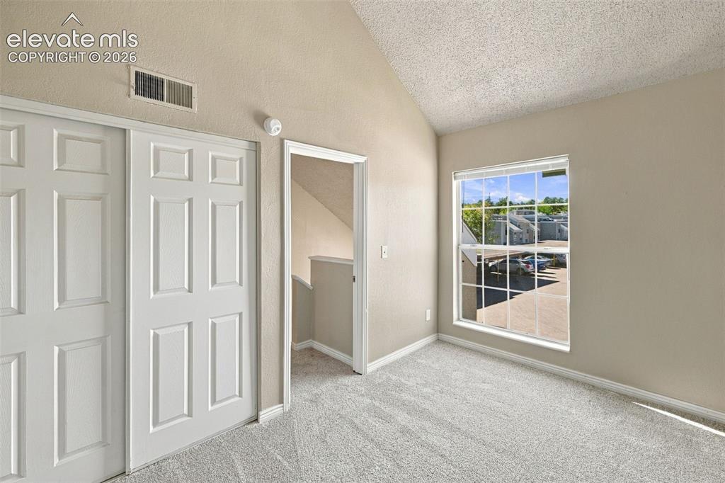 Image 11 of 26: Bright upper-level bedroom with dual closet storage, neutral carpet floorin