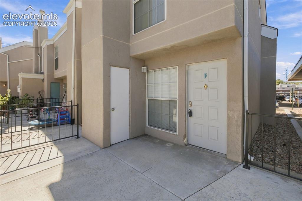 Image 2 of 26: Two-story exterior with stucco finish, concrete patio, and wrought-iron fen