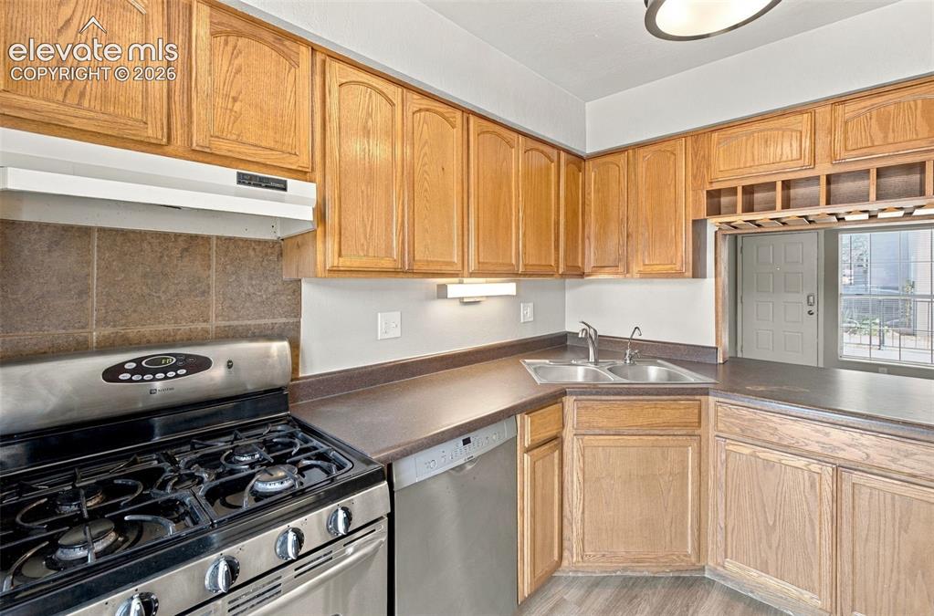 Image 9 of 26: Kitchen featuring wood cabinetry, stainless steel gas range, stainless stee