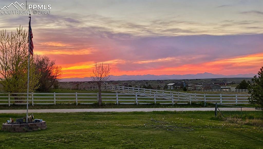 Image 11 of 50: Expansive rural landscape featuring a vibrant sunset, distant mountain rang