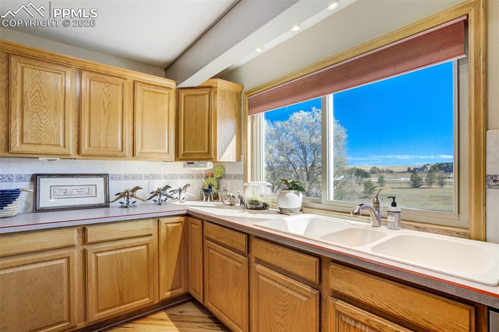 Image 17 of 50: Kitchen with light countertops, light wood finished floors, and decorative