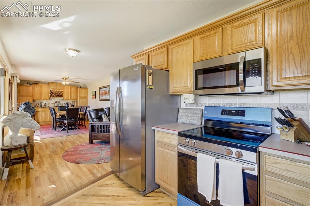Image 18 of 50: Kitchen with stainless steel appliances, light wood finish cabinetry, light
