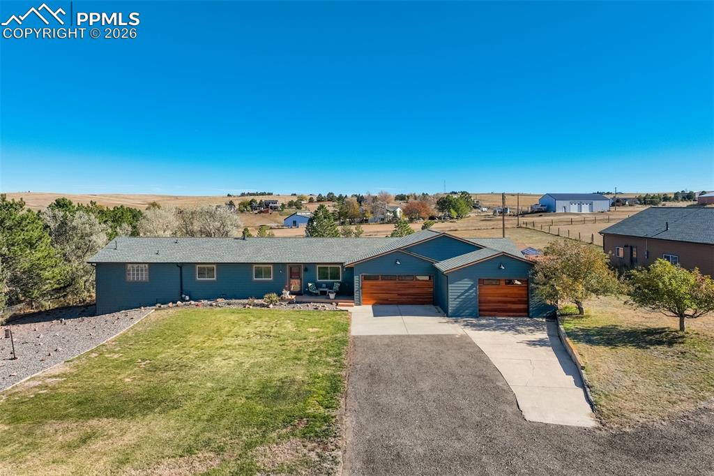 Image 2 of 50: Single story home featuring concrete driveway, a garage, and a front yard
