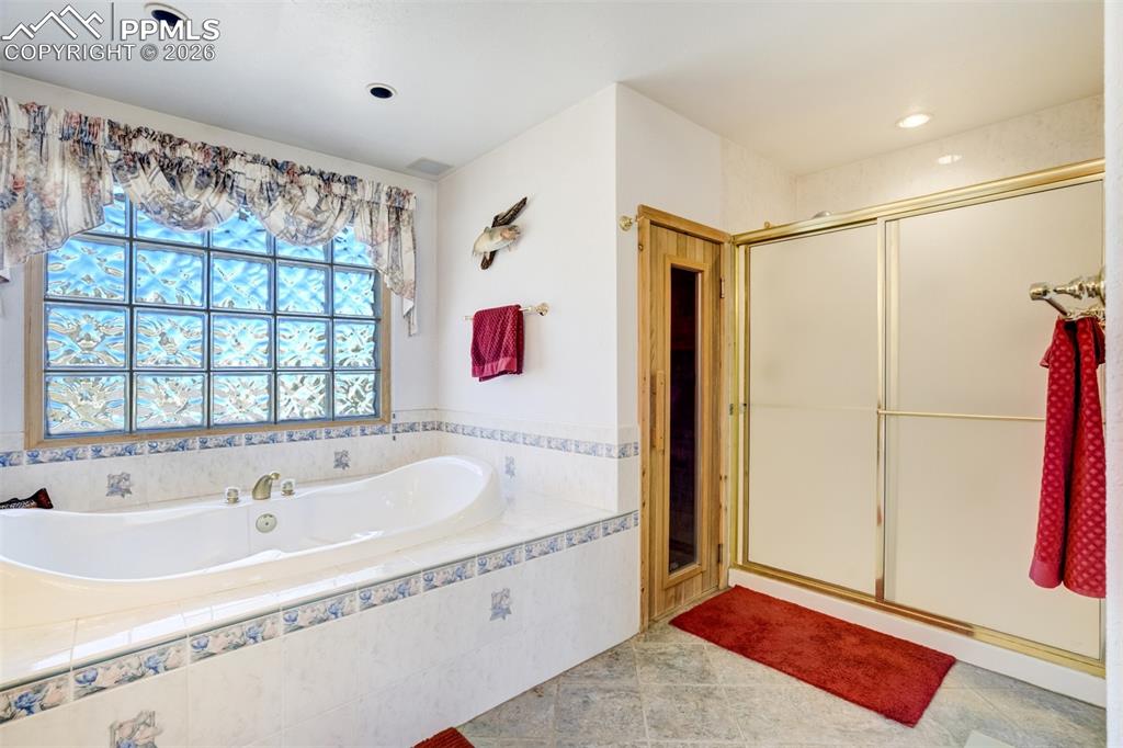 Image 22 of 50: Full bathroom featuring a shower stall and a bath