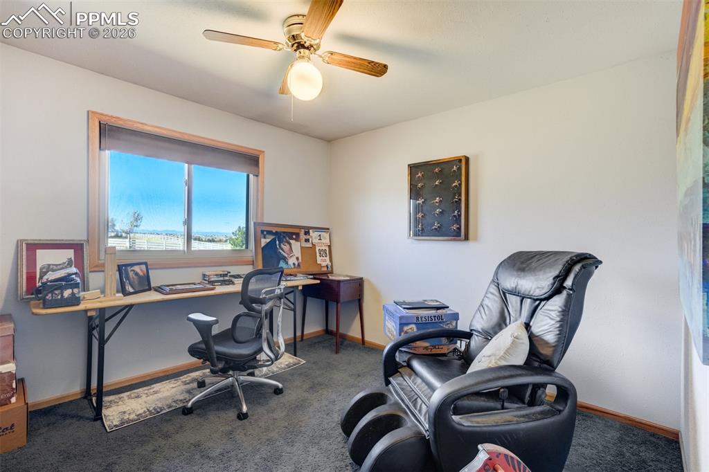 Image 28 of 50: Home office featuring dark carpet and a ceiling fan