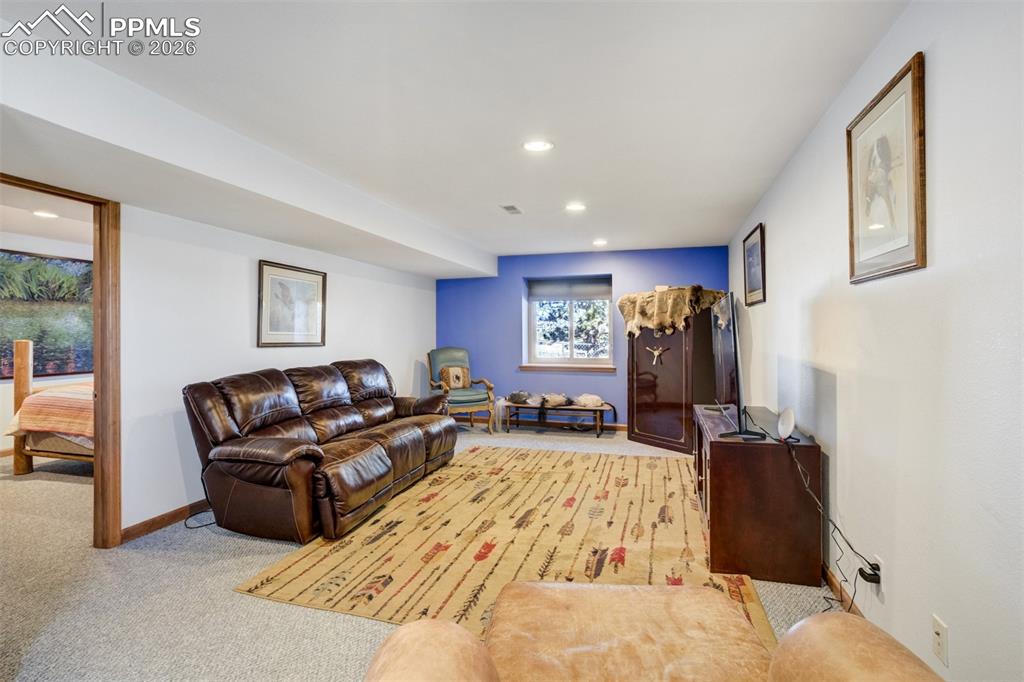 Image 35 of 50: Living area with light colored carpet and recessed lighting