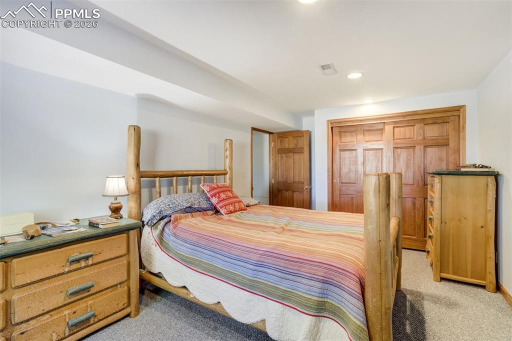 Image 37 of 50: Bedroom with light colored carpet, a closet, and recessed lighting