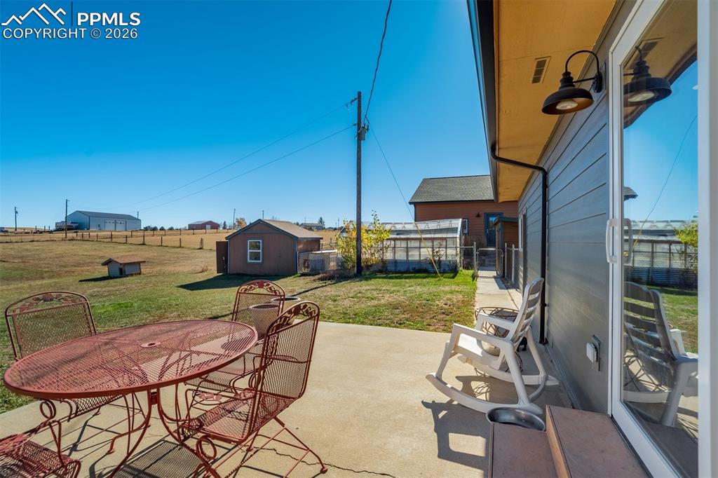Image 43 of 50: Fenced backyard with outdoor dining space, a patio, and an outbuilding