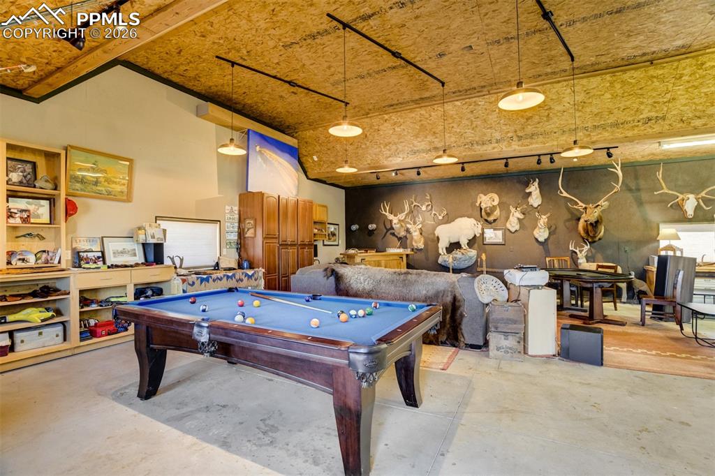 Image 49 of 50: Recreation room featuring concrete floors, pool table, rail lighting, and a