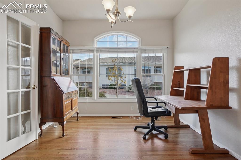 Image 16 of 42: Office space with wood finished floors, french doors and closet.