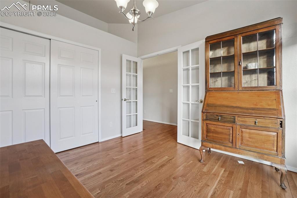 Image 17 of 42: Office space with wood finished floors, french doors and closet.
