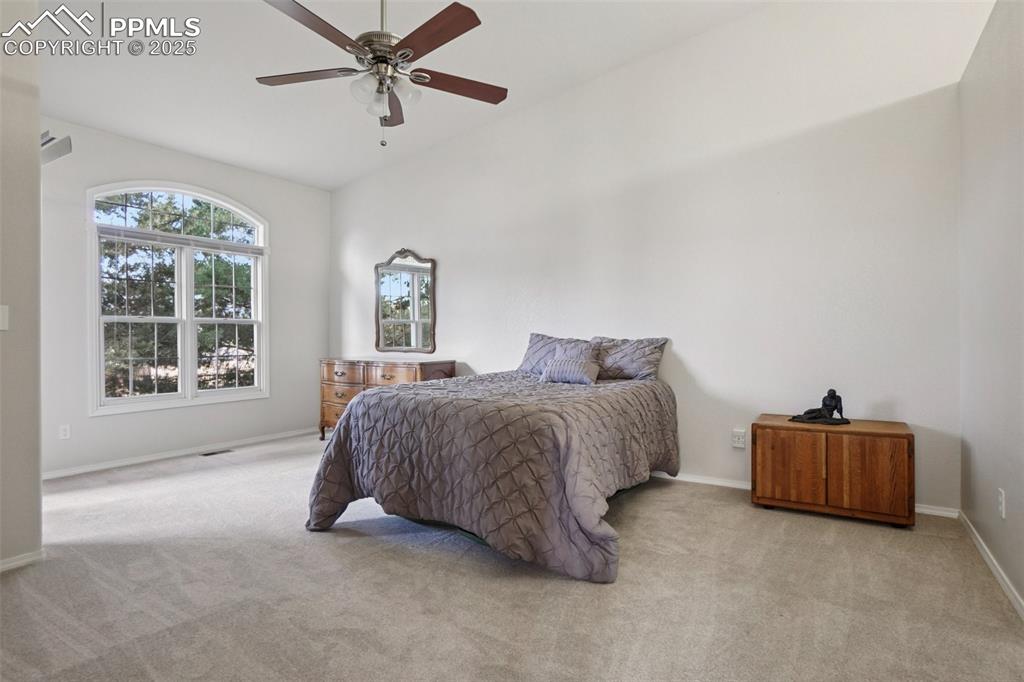 Image 20 of 42: Primary bedroom with en suite bath, deck entry and walk in closet.