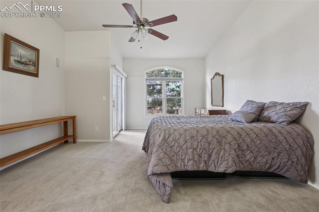 Image 21 of 42: Primary bedroom with en suite bath, deck entry and walk in closet.