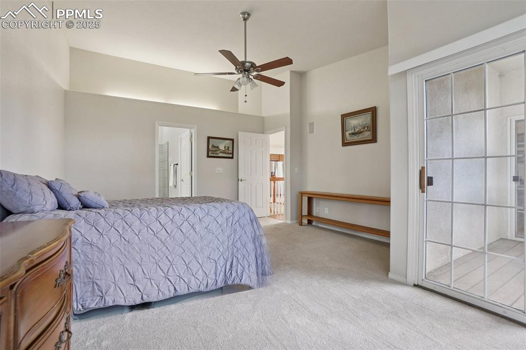 Image 22 of 42: Primary bedroom with en suite bath, deck entry and walk in closet.