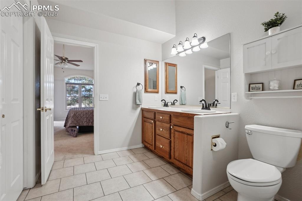Image 24 of 42: Ensuite bathroom featuring double vanity, light tile patterned flooring, a