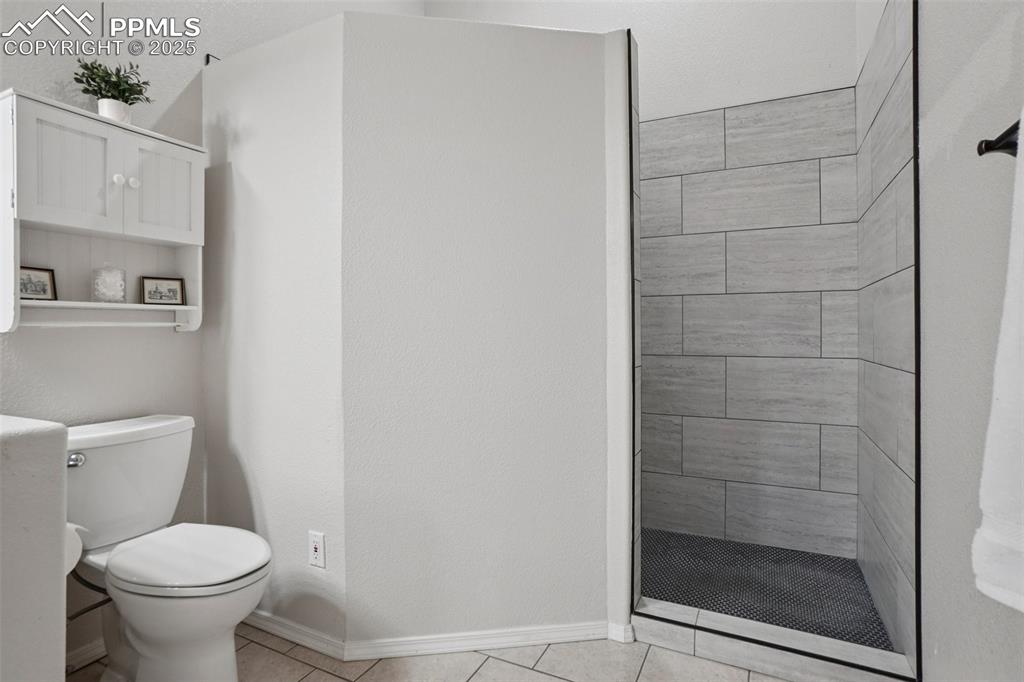 Image 27 of 42: Ensuite bathroom featuring double vanity, light tile patterned flooring, a