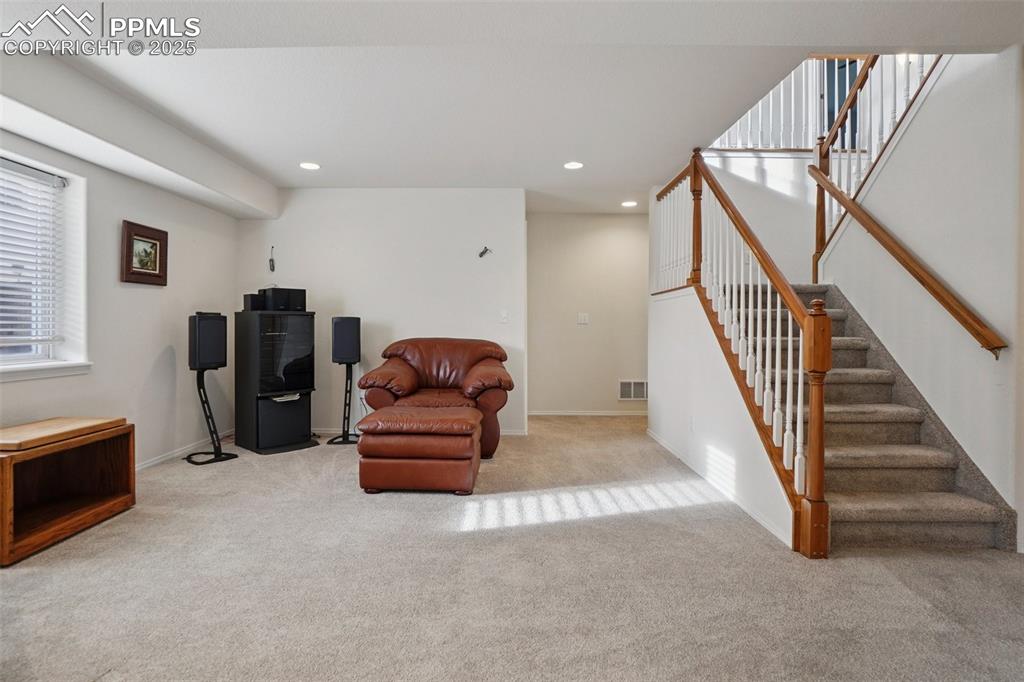 Image 30 of 42: Open den area with natural light, carpet and functional space