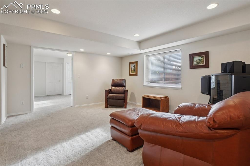 Image 32 of 42: Open den area with natural light, carpet and functional space