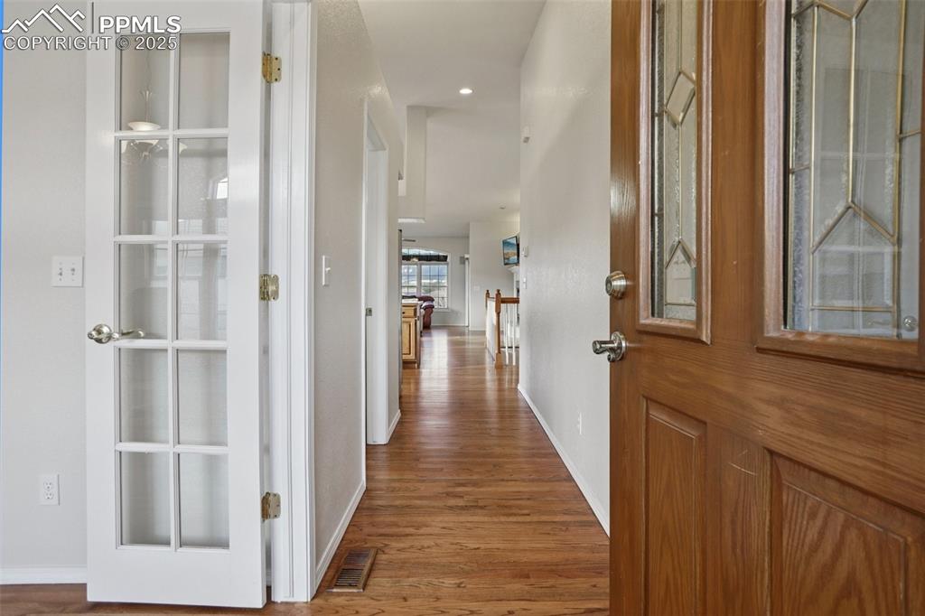 Image 4 of 42: Entryway featuring storm door, glass in front door and wood flooring recess