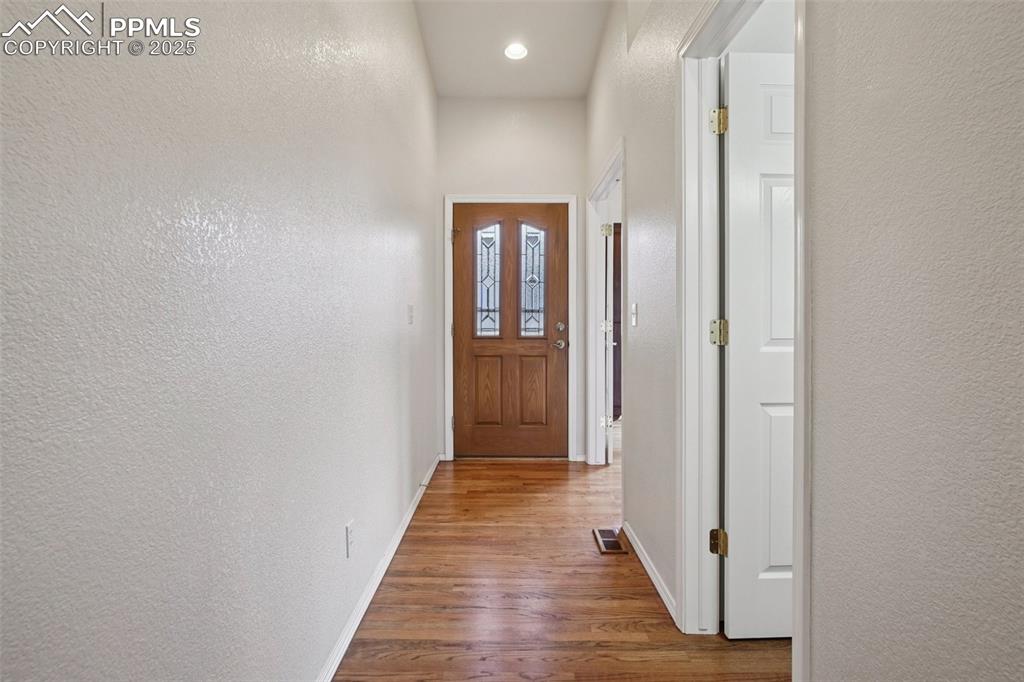 Image 5 of 42: Entryway featuring storm door, glass in front door and wood flooring recess