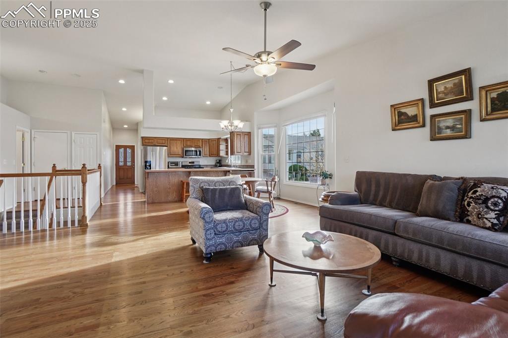 Image 8 of 42: Living area with natural wood flooring, ceiling fan, a fireplace, built in
