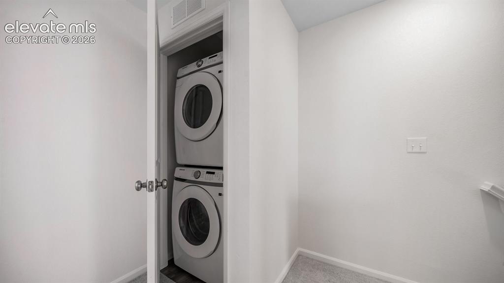 Image 13 of 24: Dedicated laundry closet featuring a stacked washer and dryer unit
*Photos