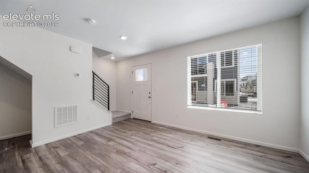 Image 15 of 24: Open-concept living space featuring wood-finish flooring, recessed lighting