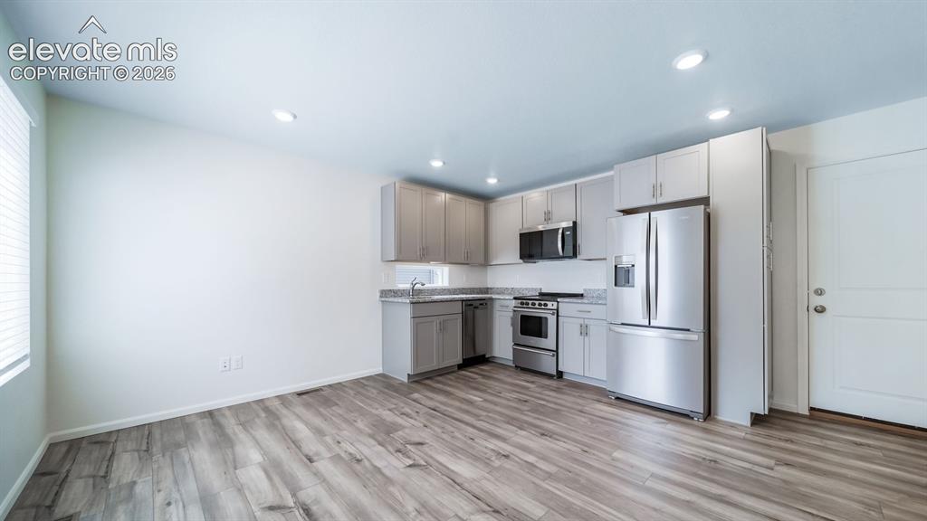 Image 17 of 24: Kitchen featuring light gray cabinetry, stainless steel appliances, speckle