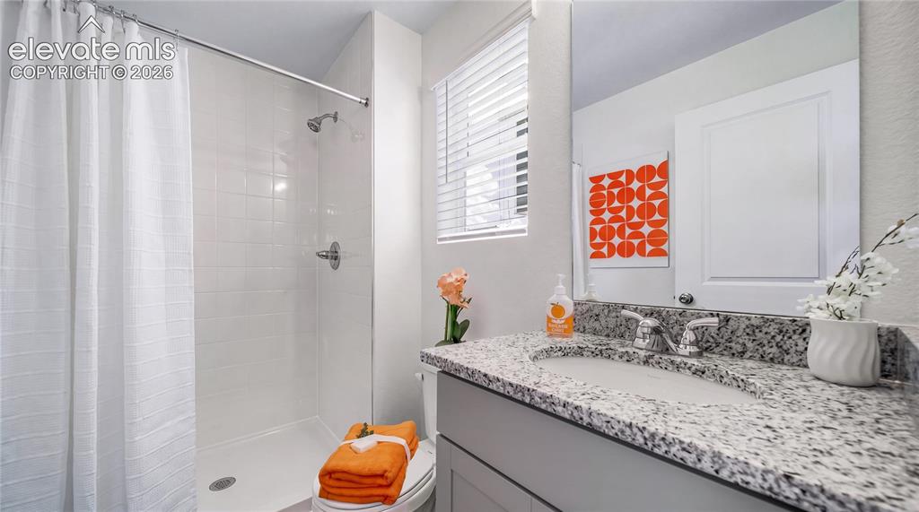 Image 2 of 24: Bathroom featuring a white subway tile shower, chrome shower fixtures, a si