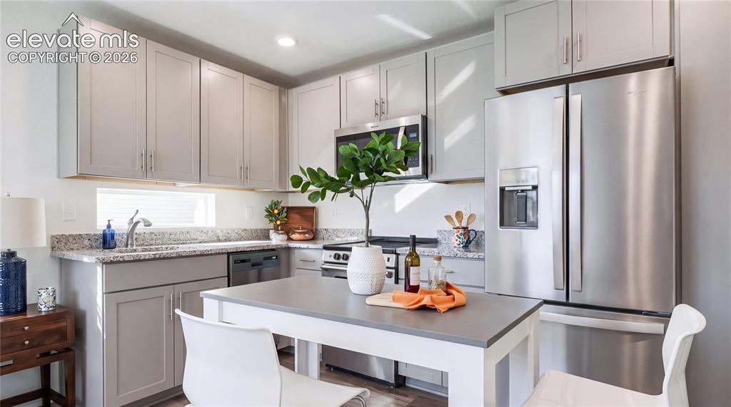 Image 3 of 24: Contemporary kitchen featuring light gray cabinetry, stainless steel applia