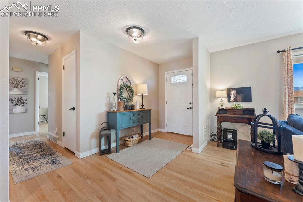 Image 3 of 45: Entrance foyer with light wood-type flooring and a textured ceiling