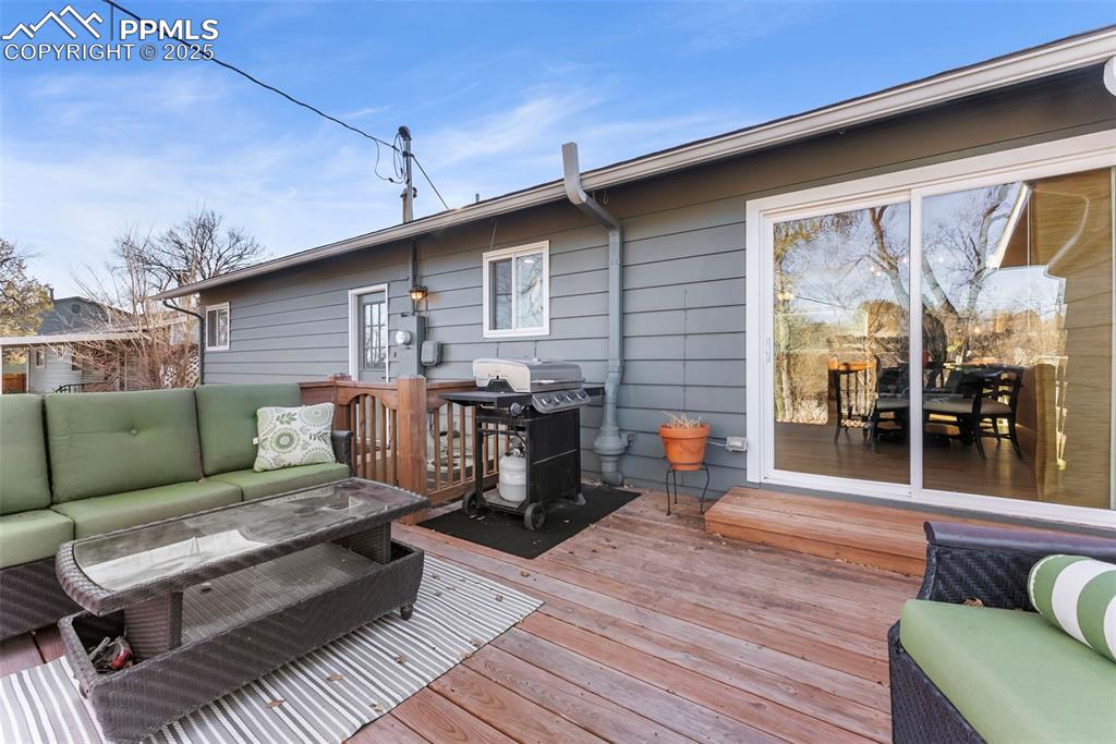 Image 32 of 45: Wooden terrace with an outdoor living space and a grill