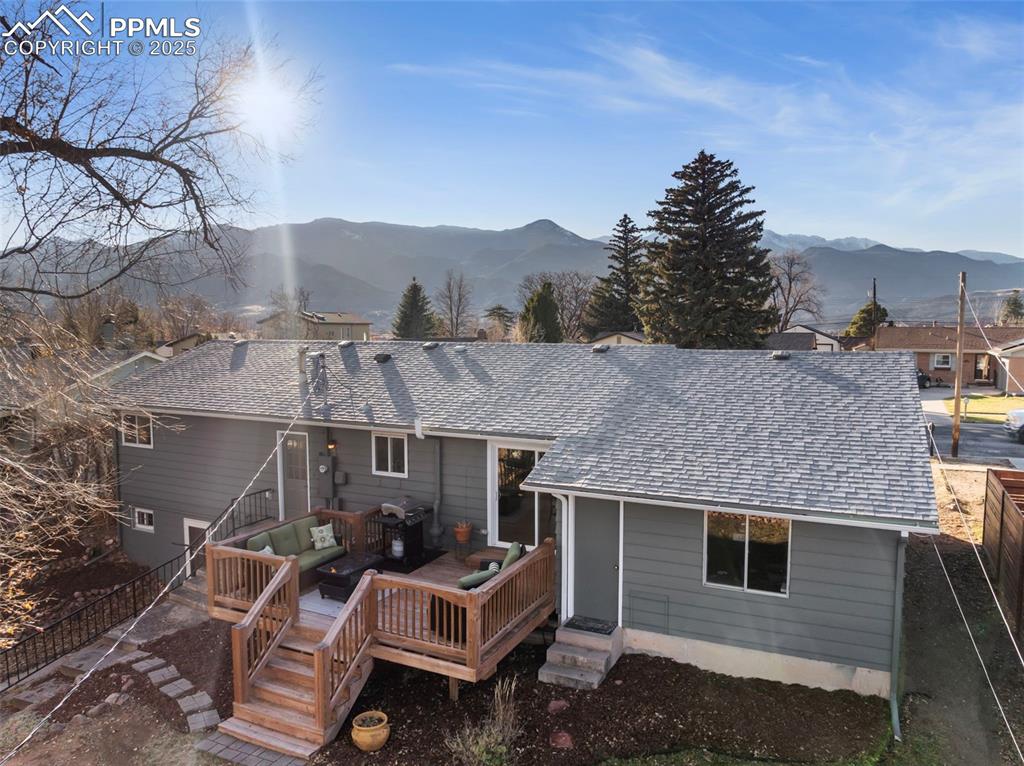 Image 39 of 45: Rear view of property featuring a shingled roof, a deck with mountain view,