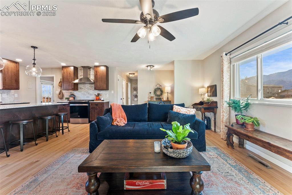 Image 7 of 45: Living area featuring light wood-style floors, a ceiling fan, and a mountai