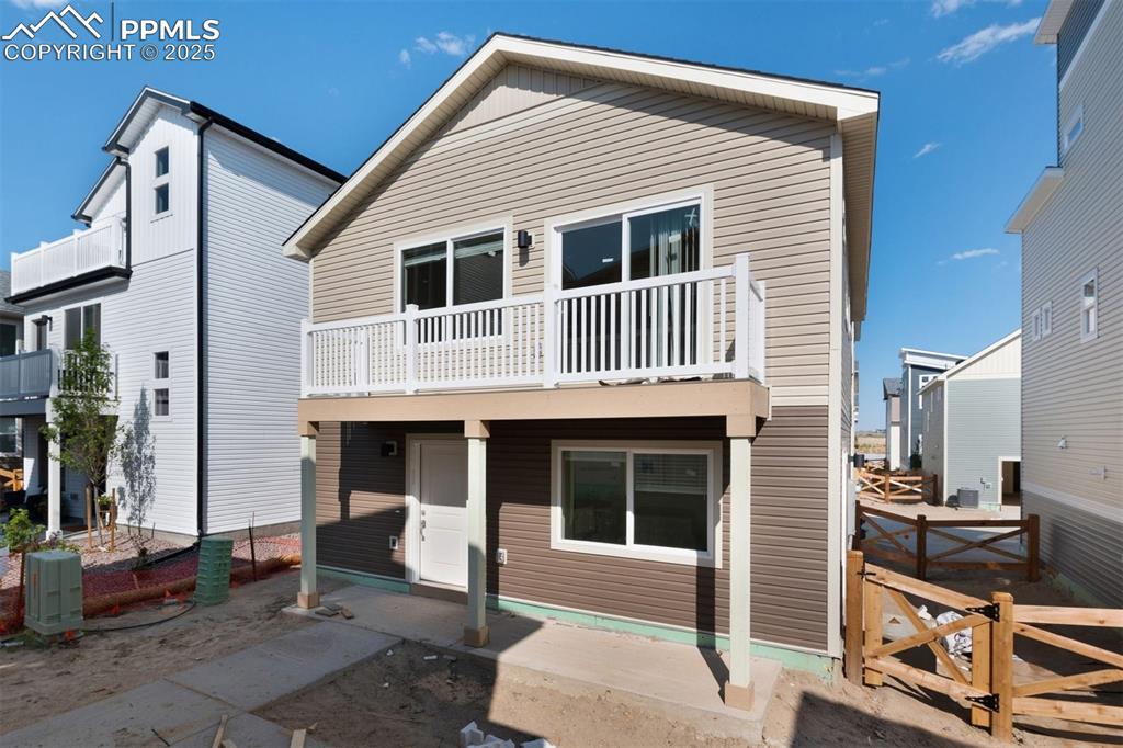 Image 4 of 7: Rear view of property with a gate, a balcony, and a patio area