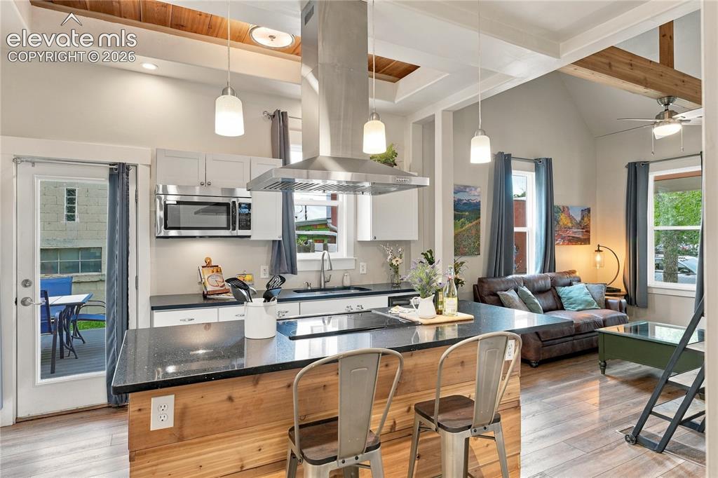 Image 12 of 50: View of kitchen from Primary bedroom suite. Walk out to the deck and covere