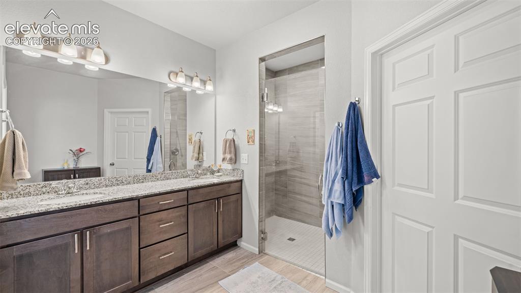 Image 17 of 34: Double vanity featuring a light-toned granite countertop and dark wood-fini