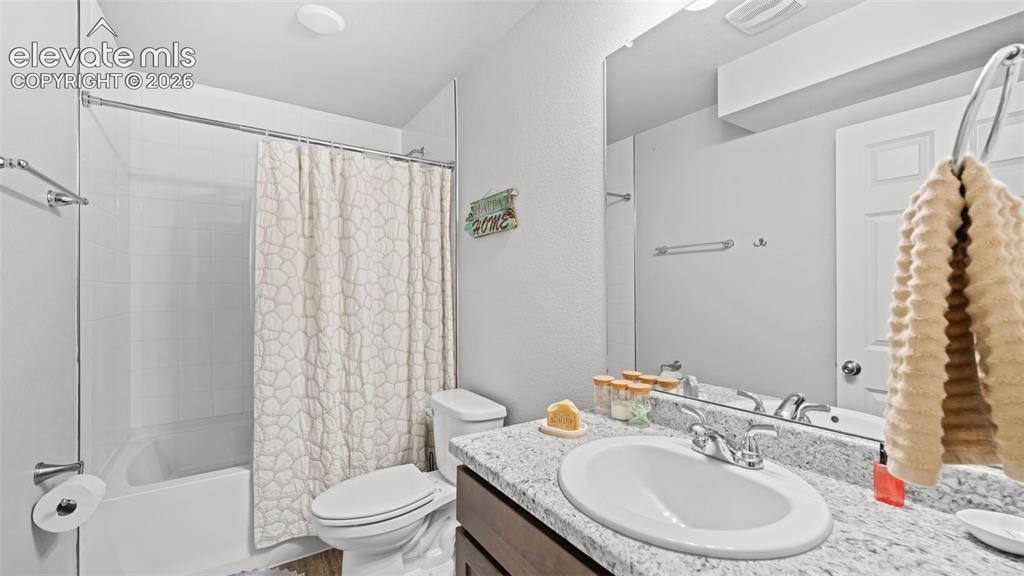 Image 24 of 34: Bathroom featuring a white bathtub with subway tile surround, a toilet, and