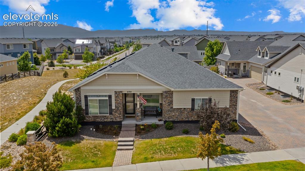 Image 29 of 34: Single-story residence featuring a gray shingle roof and a façade combining