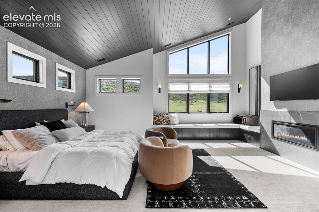 Image 10 of 38: Primary suite with vaulted ceilings and built-in window bench.