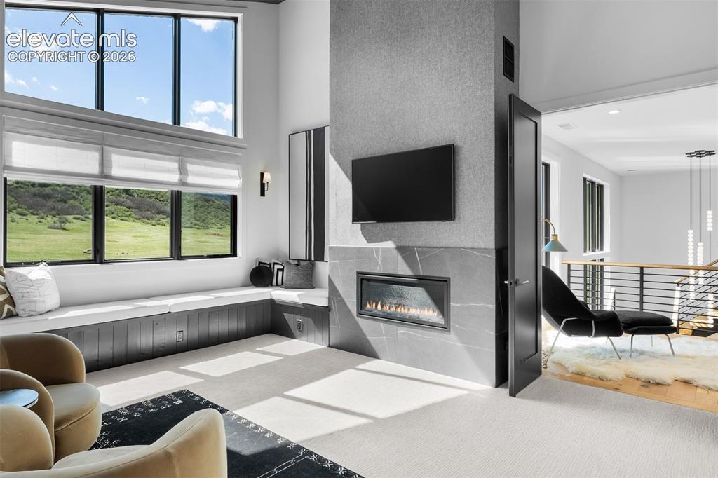 Image 18 of 38: Linear fireplace enhancing the primary retreat.