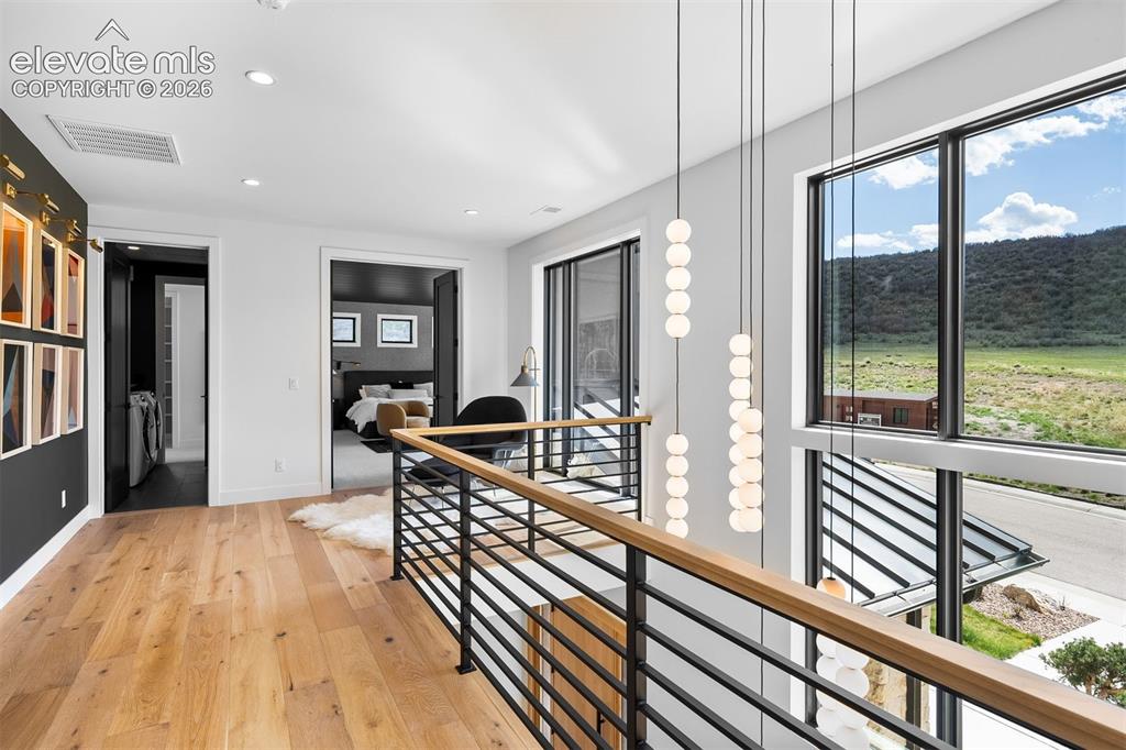 Image 20 of 38: Upper-level landing surrounded by expansive windows and modern railing deta