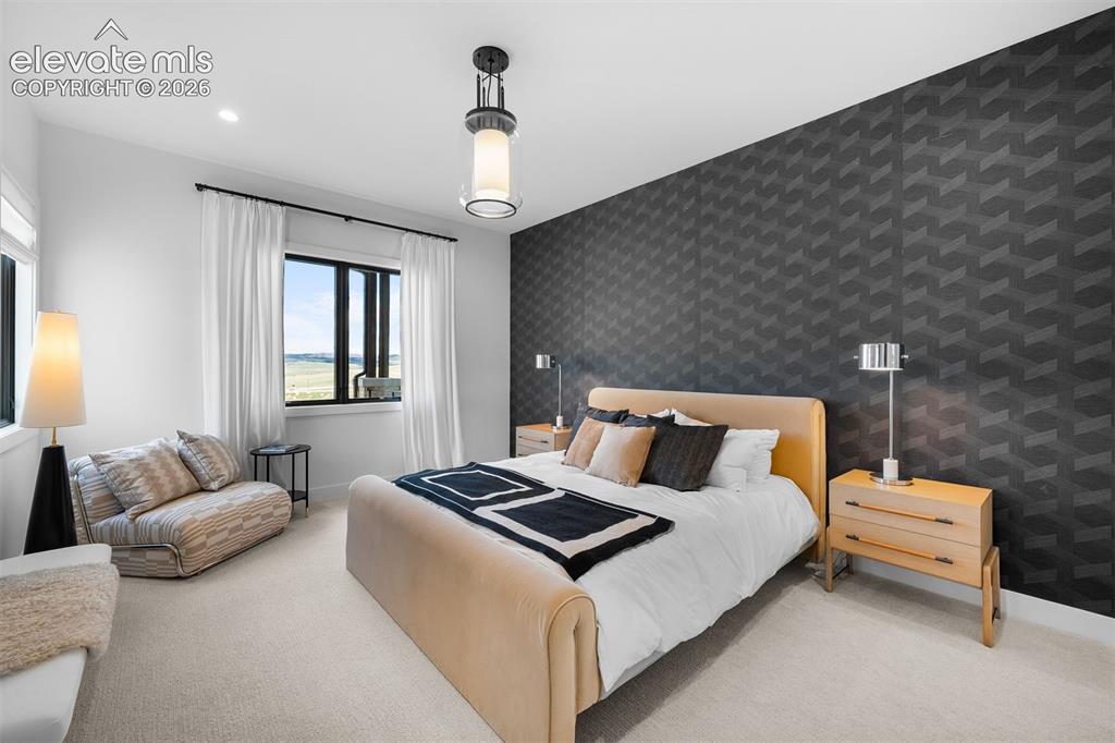 Image 21 of 38: Bedroom featuring statement accent wall and layered modern finishes.