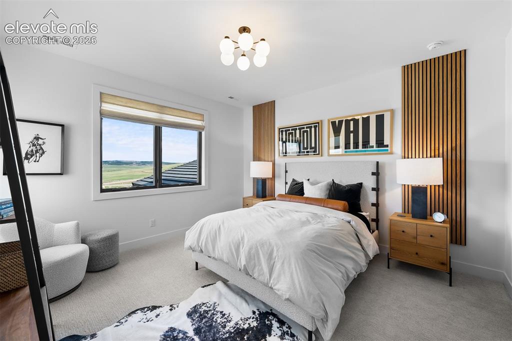 Image 24 of 38: Bedroom with custom vertical wood accents and framed views.