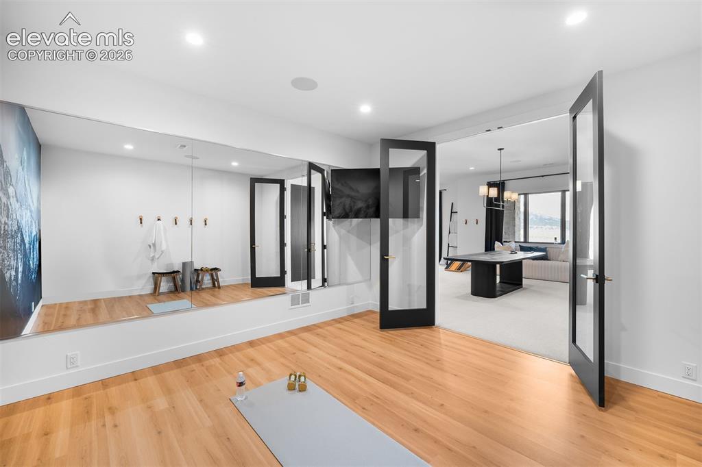 Image 29 of 38: Dedicated wellness space with full-height mirrors and flexible design.