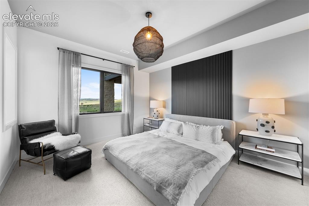 Image 32 of 38: Bedroom anchored by vertical black slat feature wall.